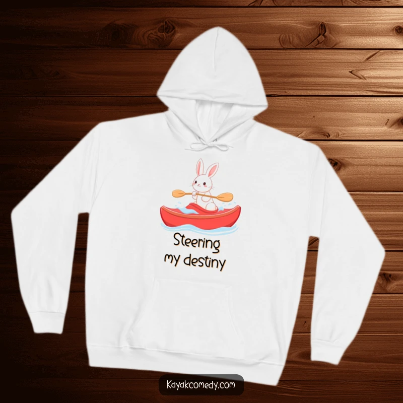 Funny Hoodie: A smiling rabbit steers a red kayak through gentle waves, a symbol of calm adventure. Great gift.